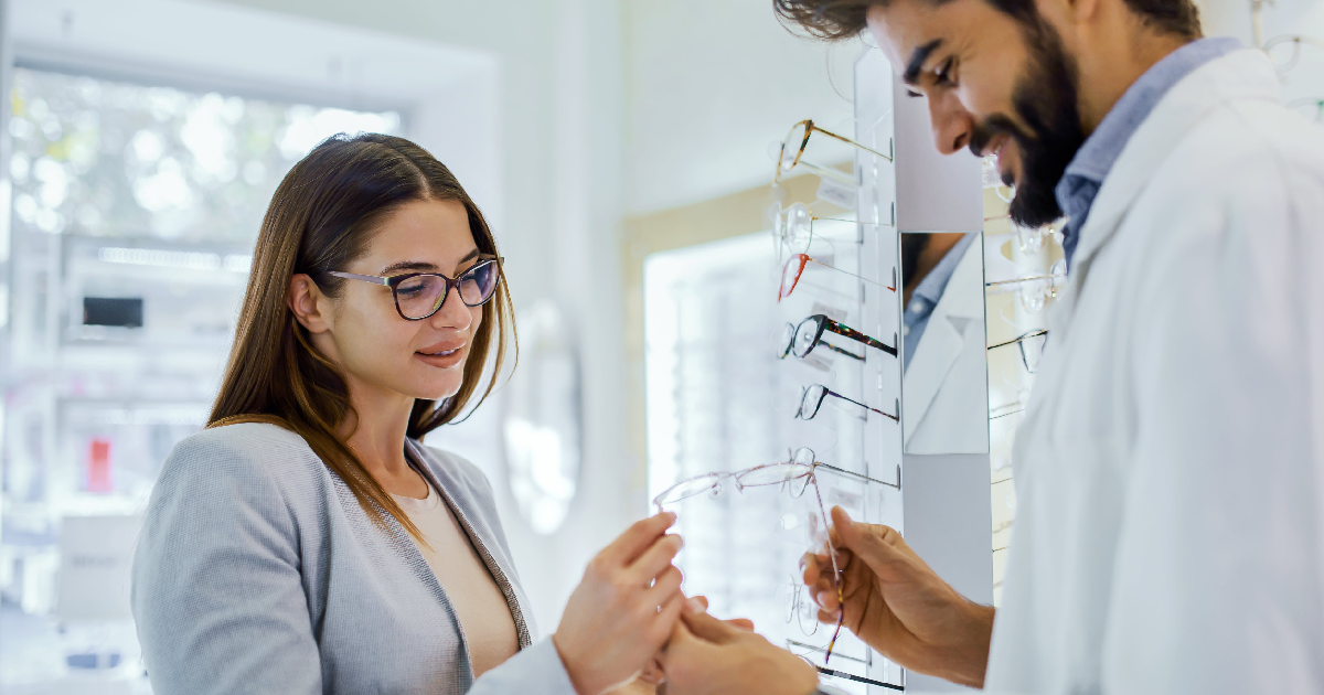 Woman receiving expert guidance during a Frame Style Consultation in Glenview, IL, selecting eyeglass frames that suit her face shape