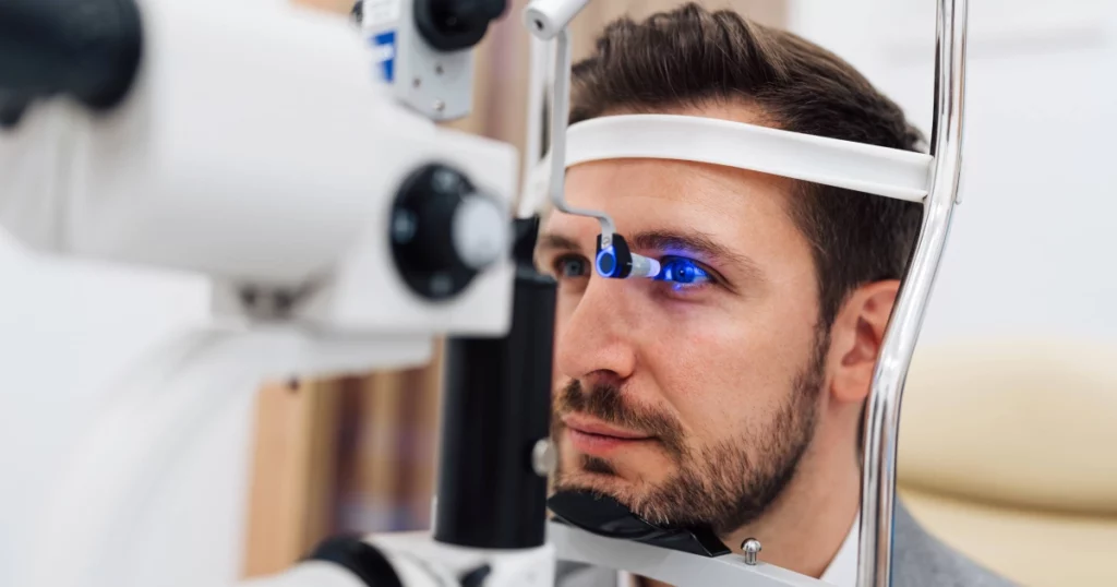 A man undergoing Vision Therapy in Glenview, IL, using a slit lamp with blue light focused on his eye.